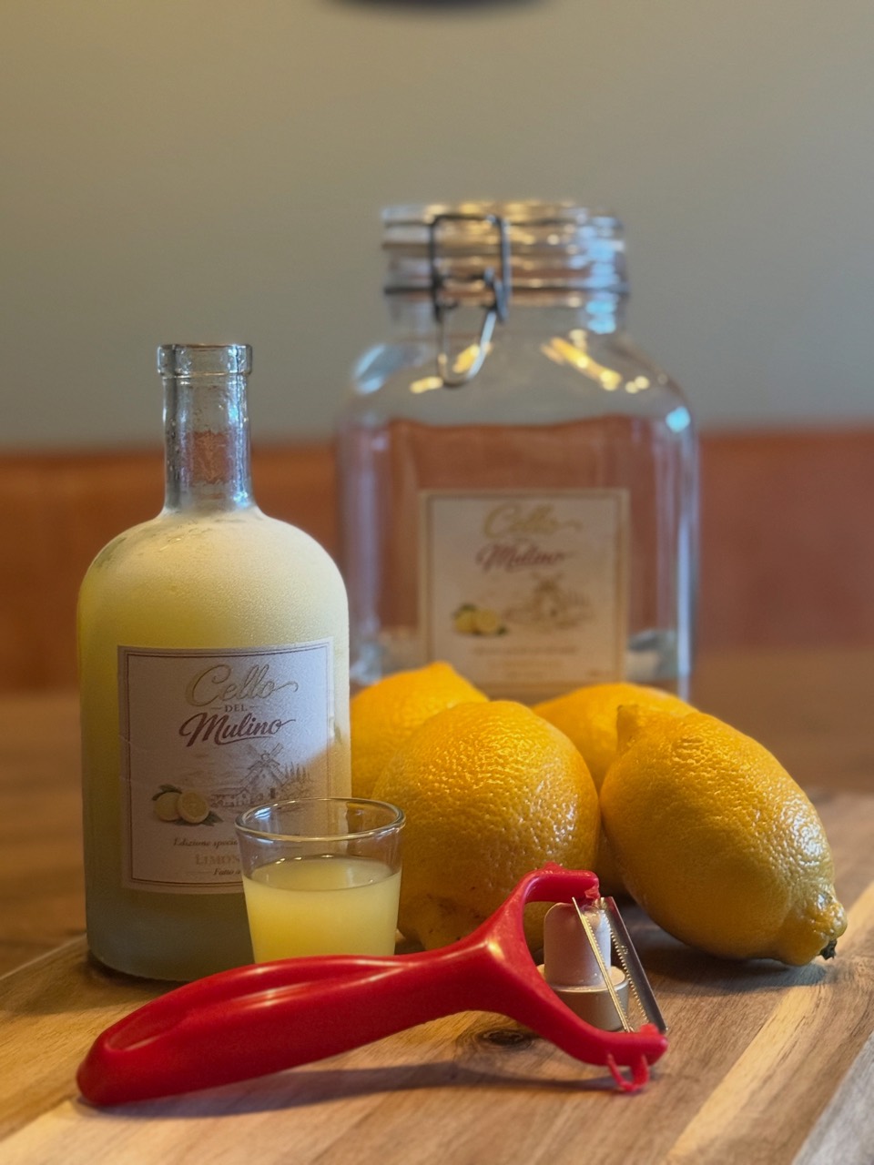 Limoncello, citroenen en handschiller op houten tafel